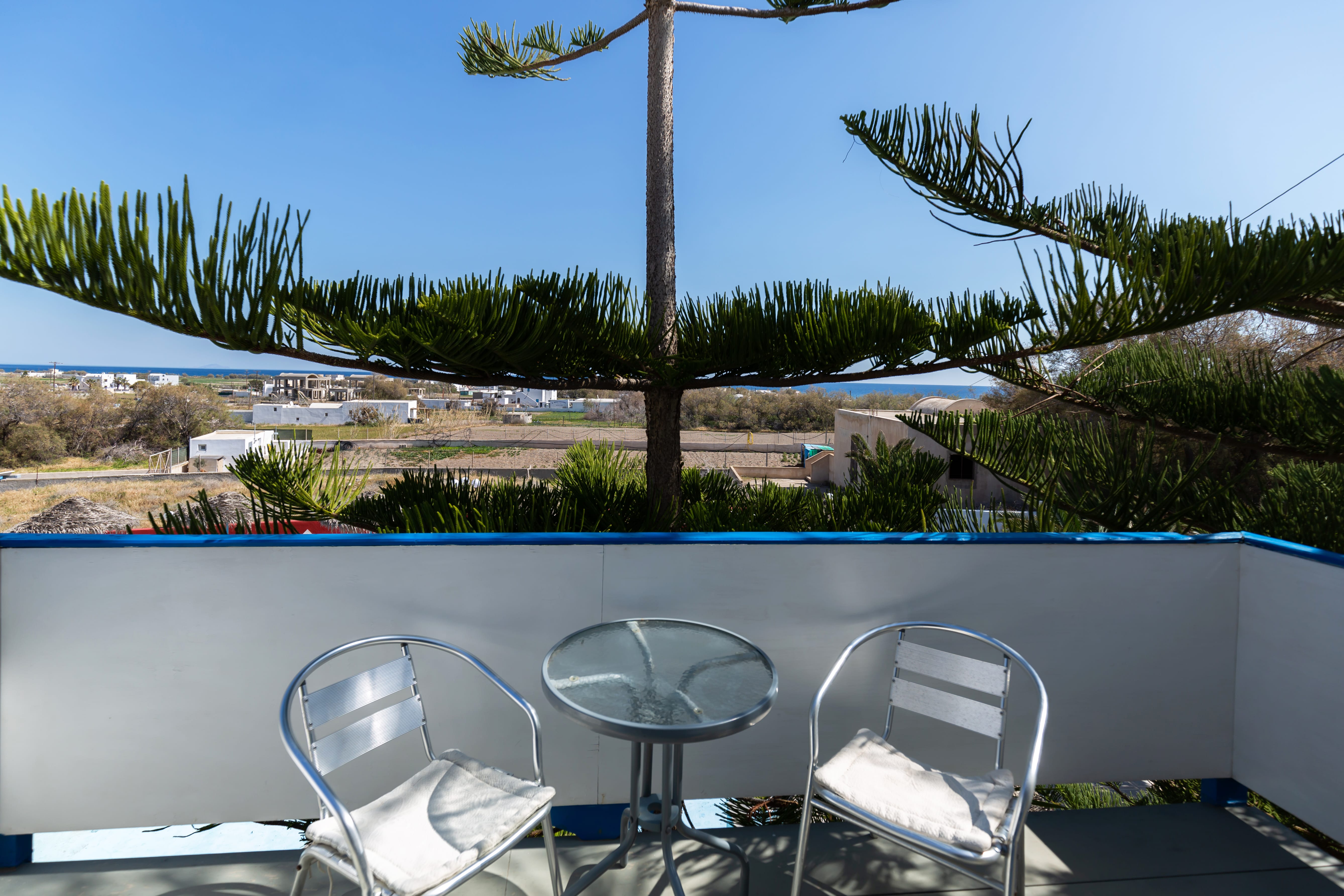 a deck with chairs and a body of water in the background