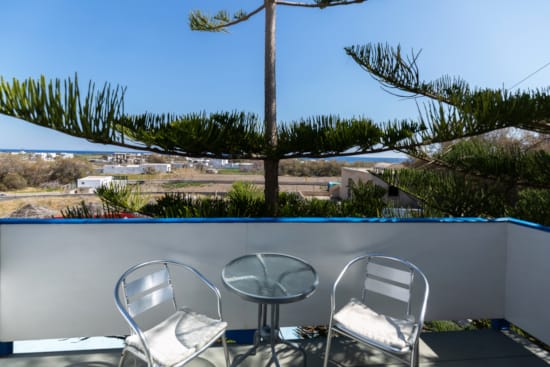 a deck with chairs and a body of water in the background