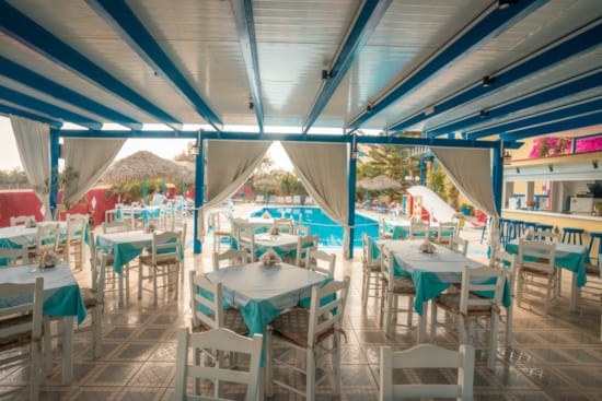 a group of tables and chairs in a room with a covered area