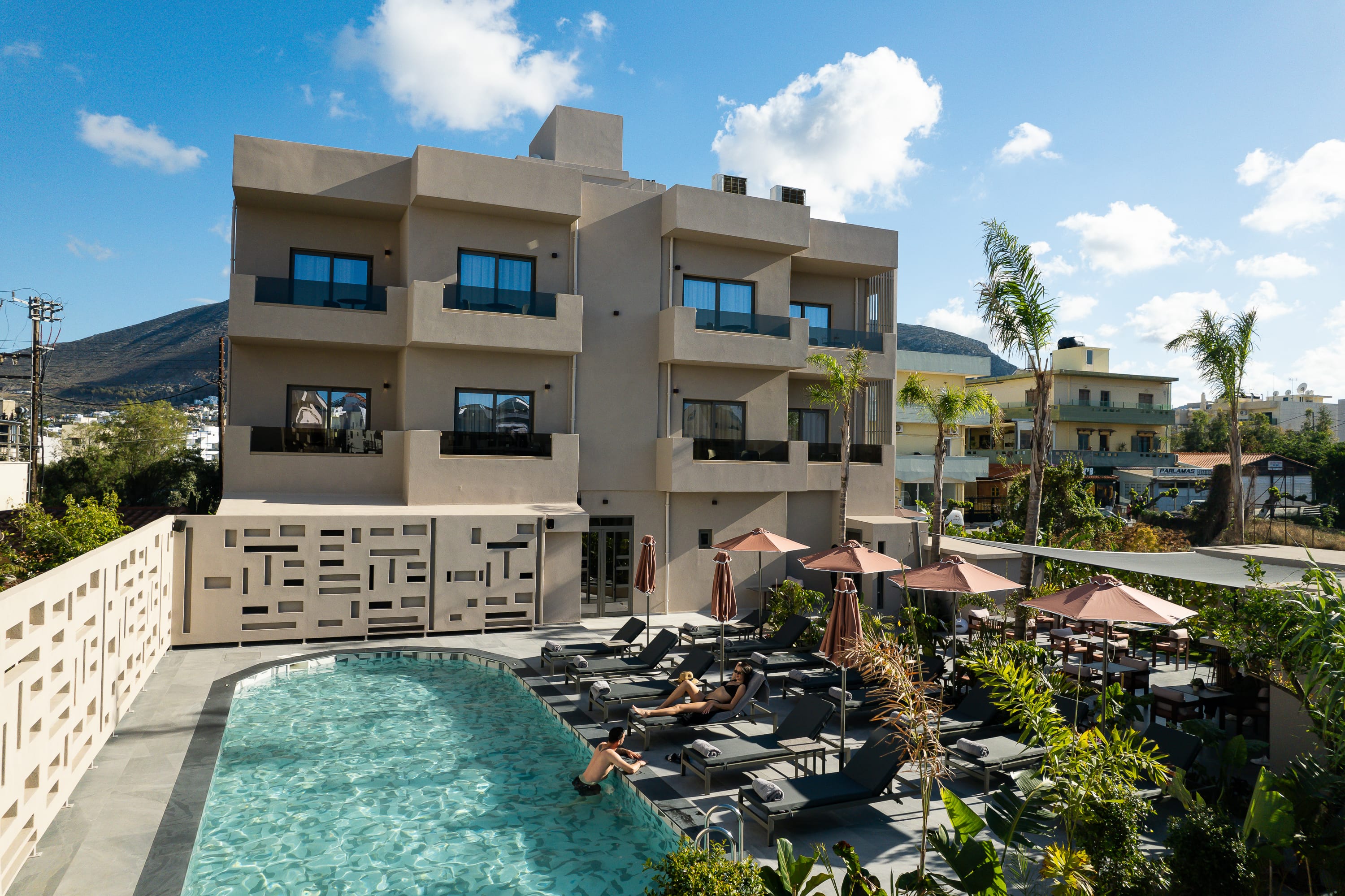 a building with a pool and palm trees