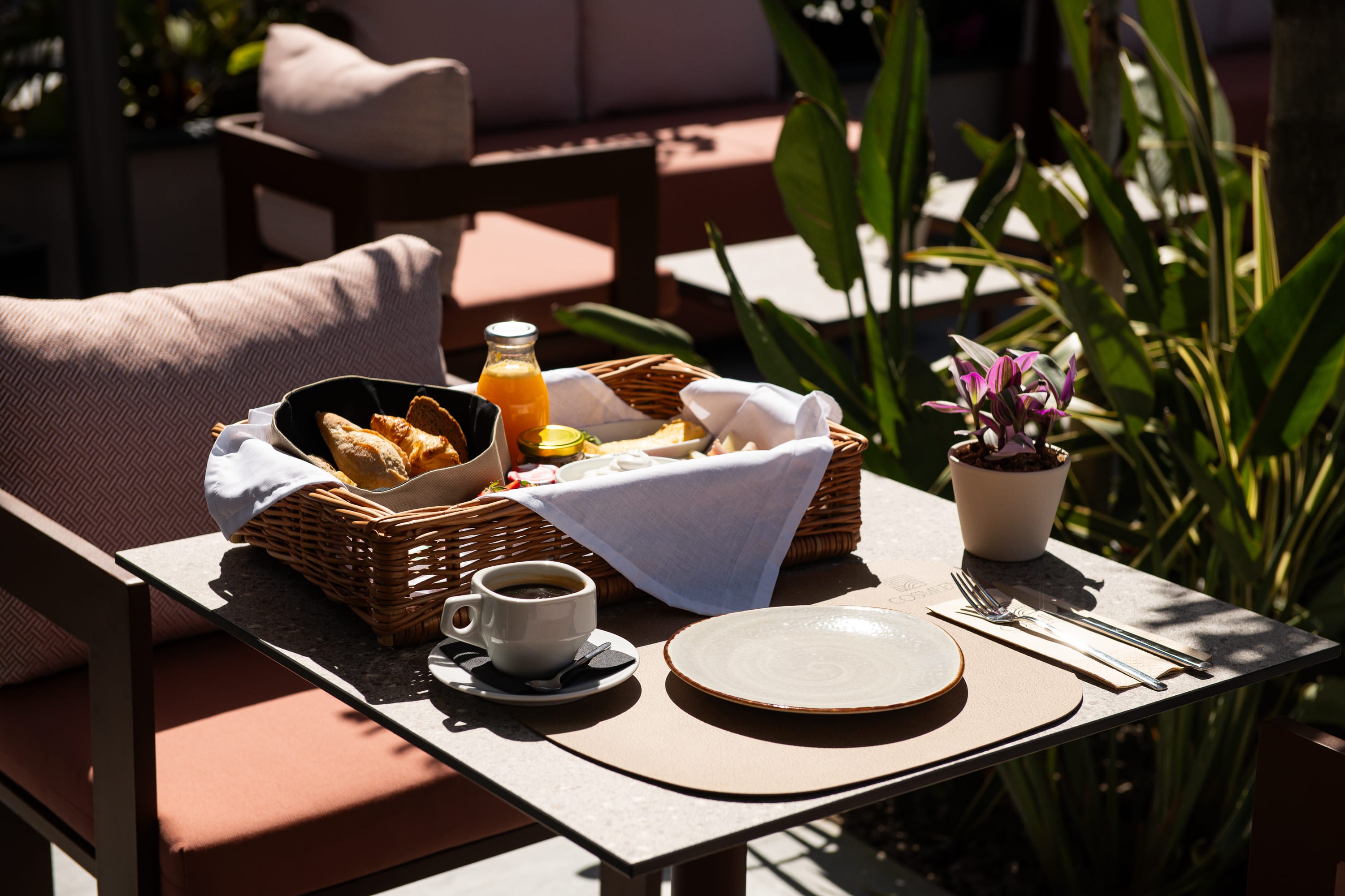 a table with a basket of cookies and coffee