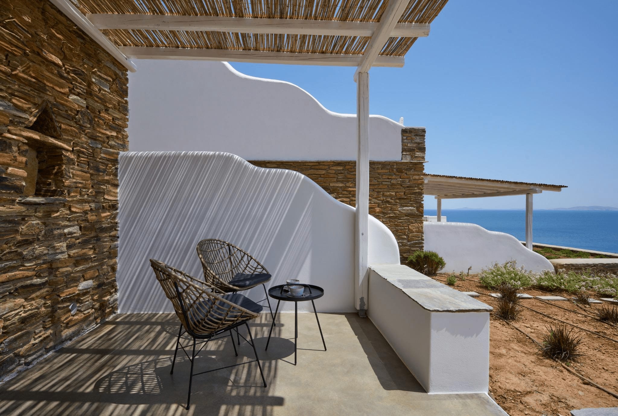 a patio with a white tent and chairs on it