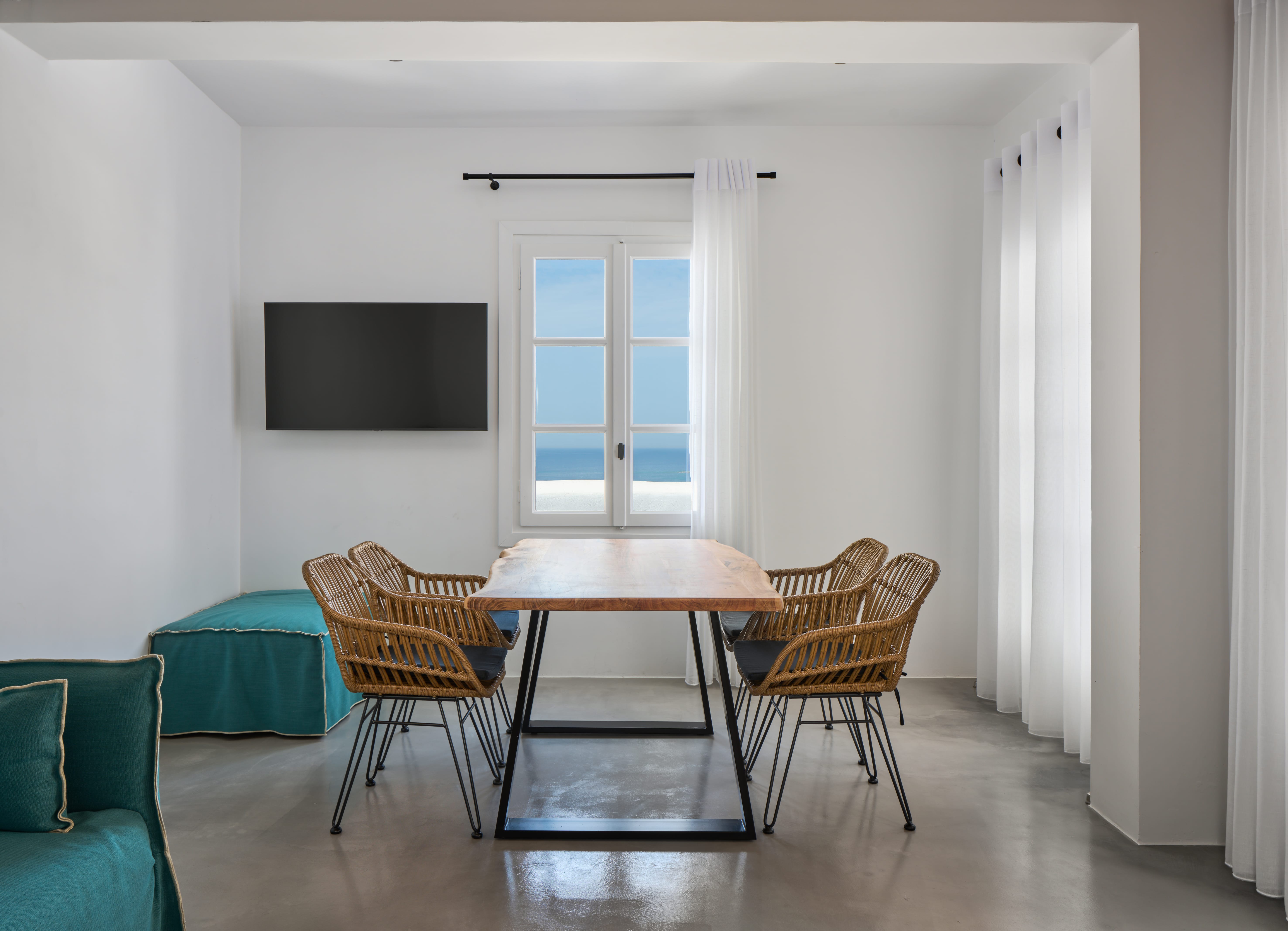 a room with a table chairs and a tv