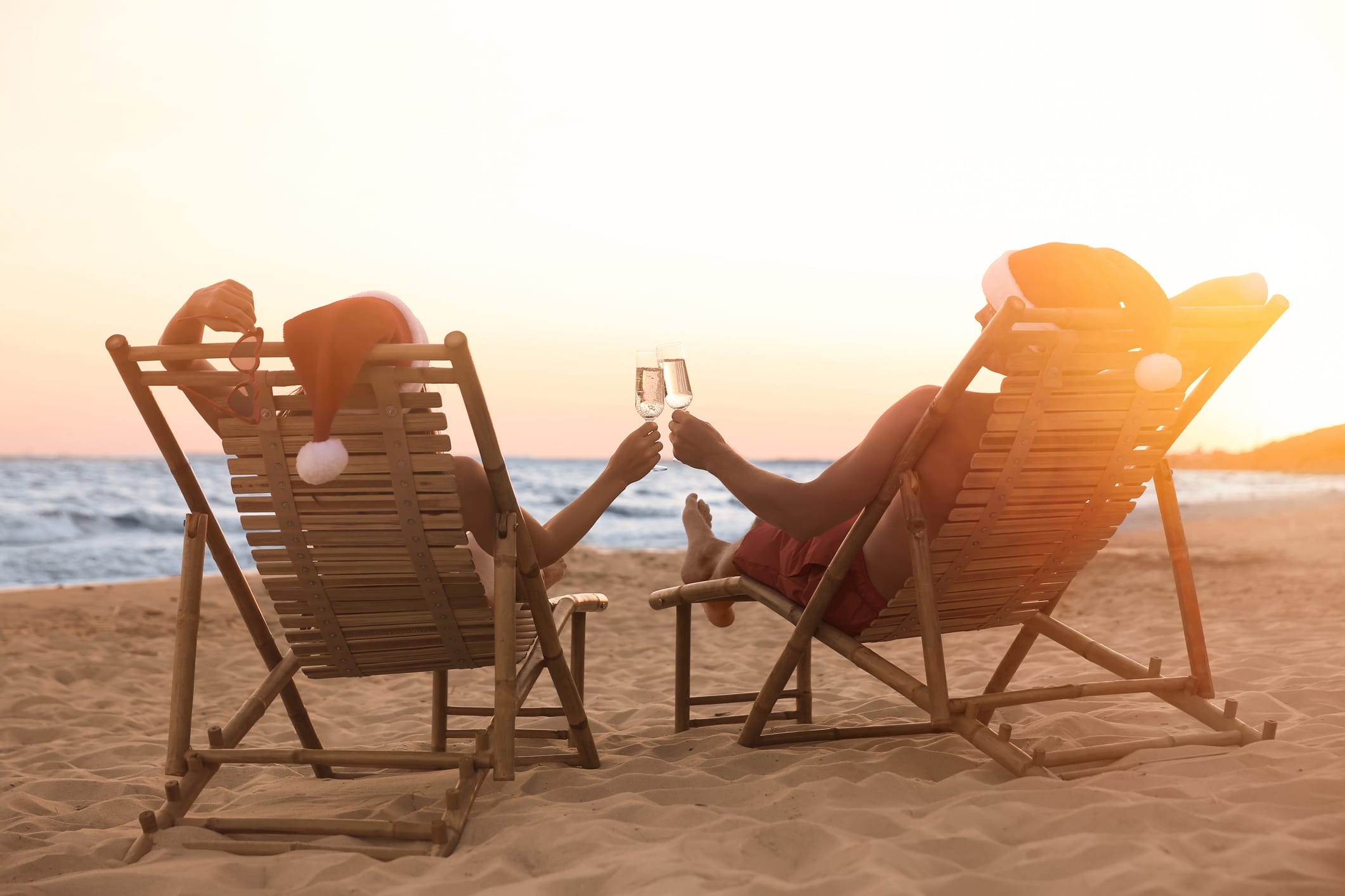a couple of people sitting in chairs on a beach