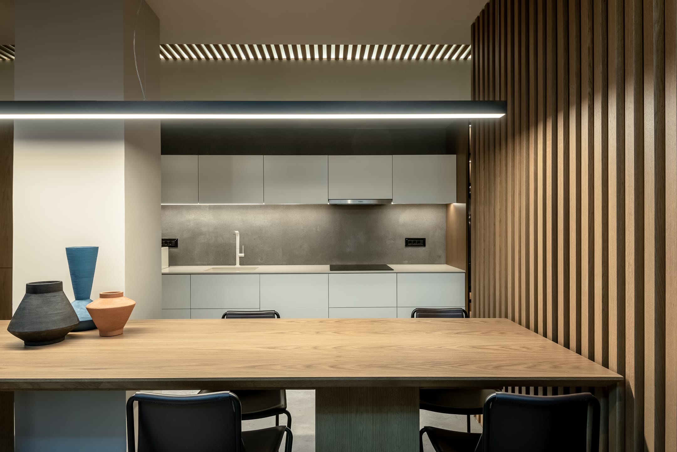 a table with a chair and a shelf with a light above it