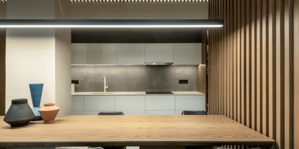 a table with a chair and a shelf with a light above it