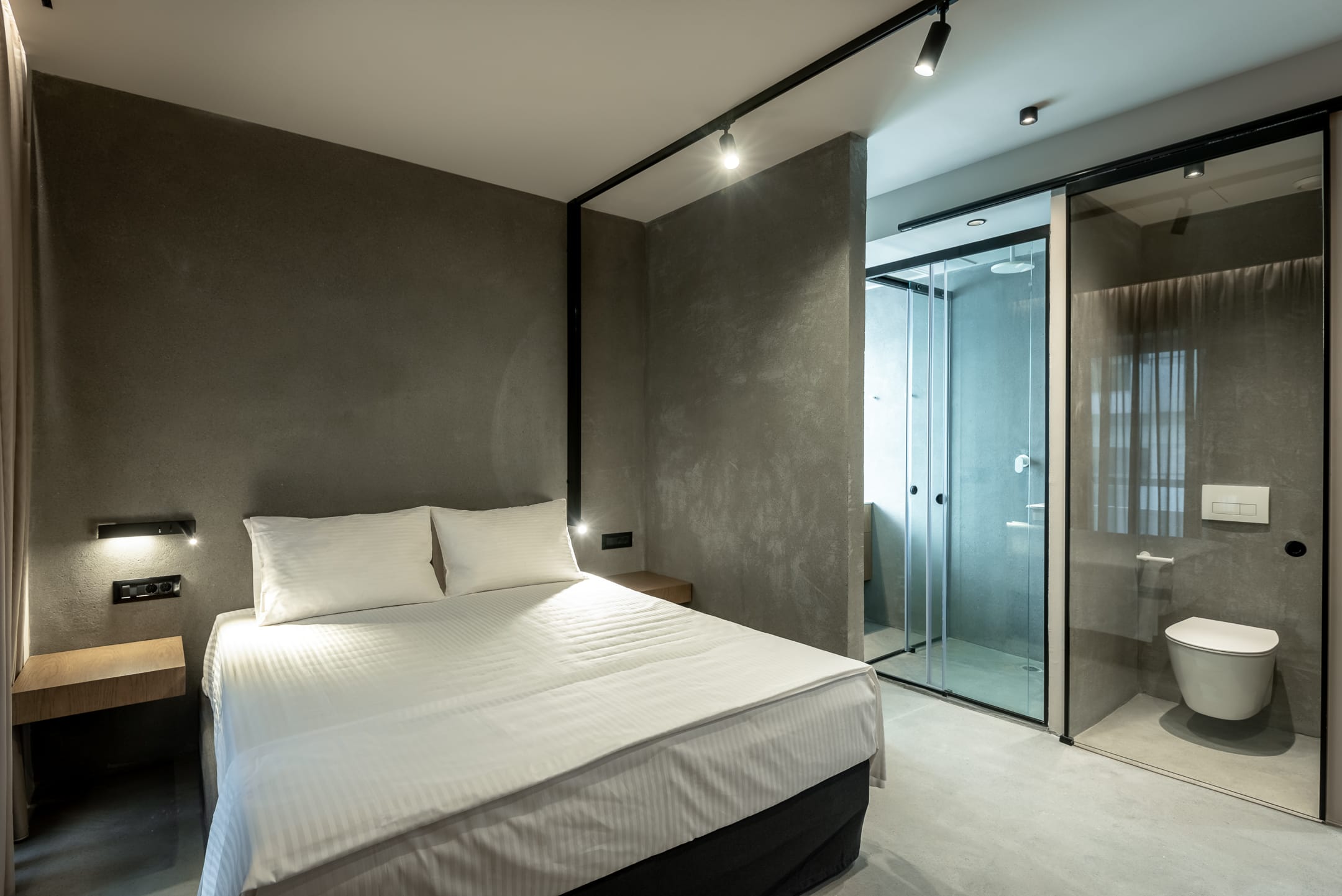 a bedroom with a large glass shower