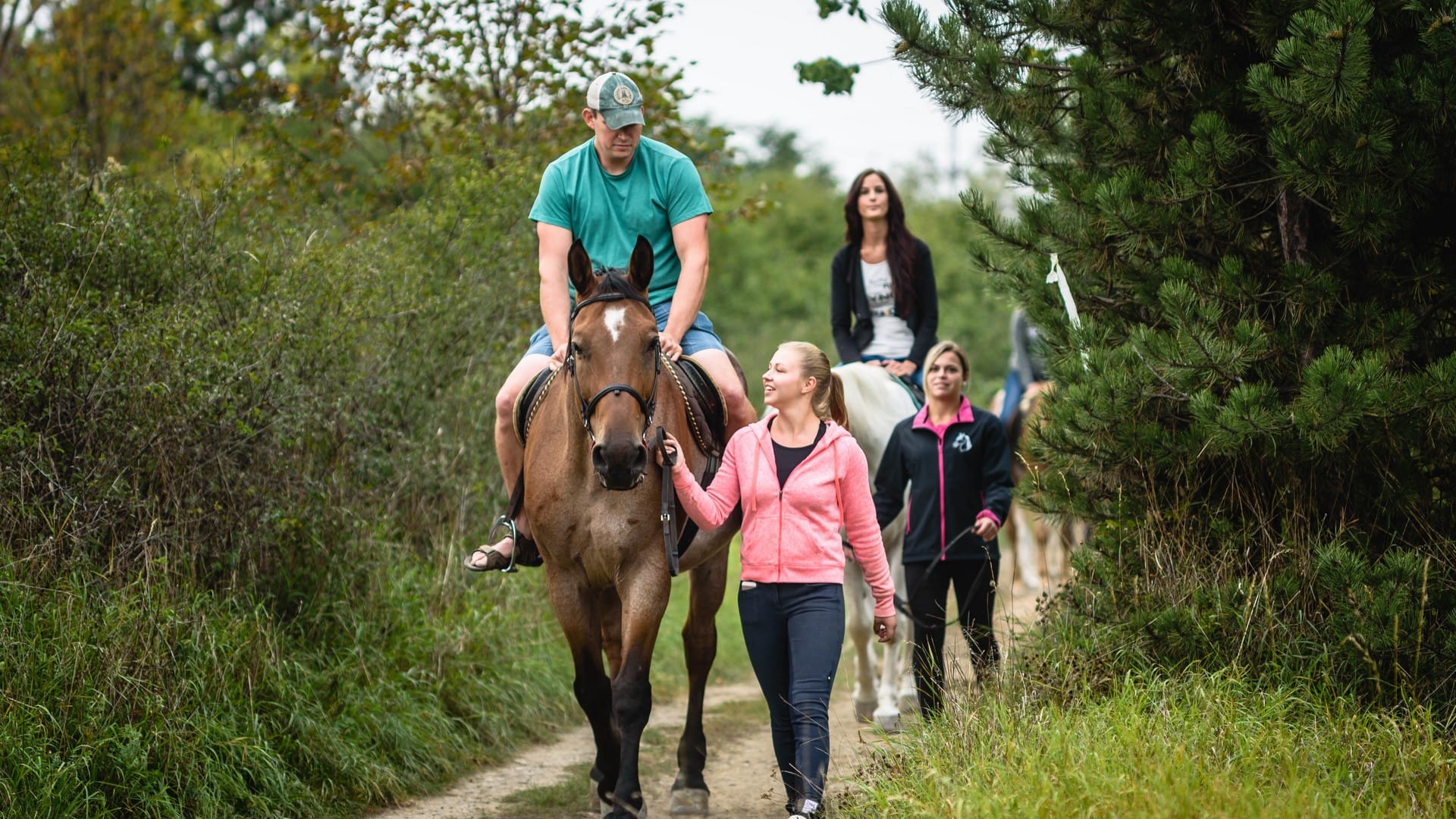 a group of people walking a horse