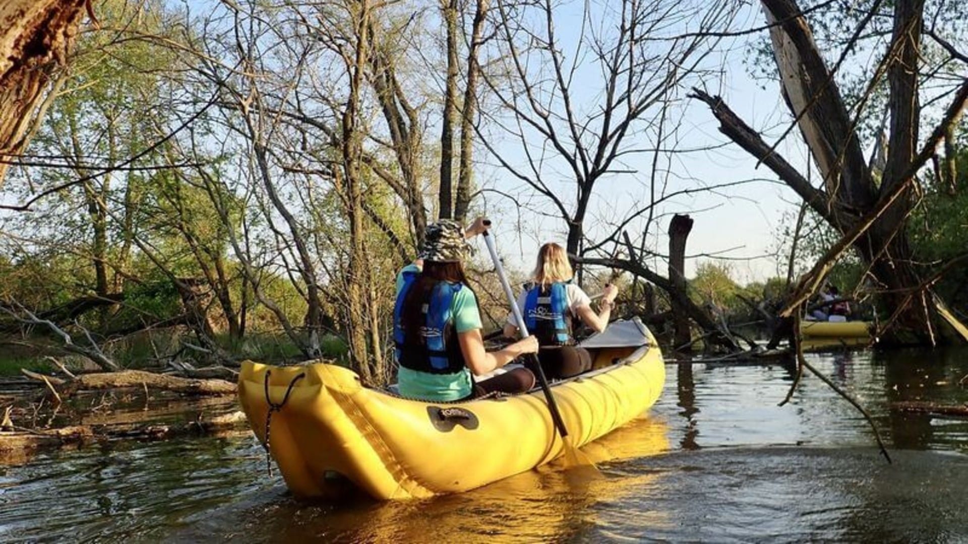 a group of people in a yellow canoe on a river