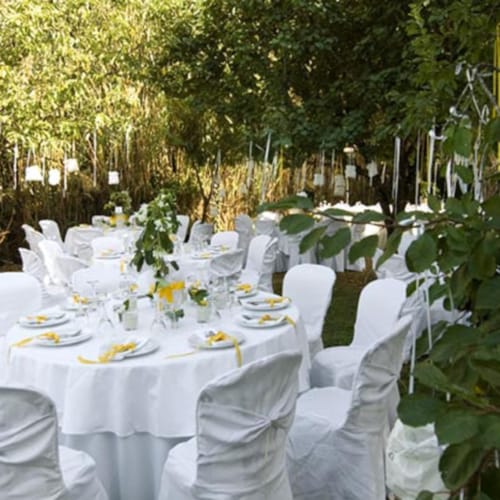 a set table with white chairs and white tables