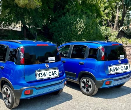 a couple of blue cars parked next to each other
