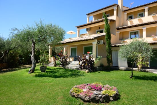 a large building with a lawn and trees in front of it