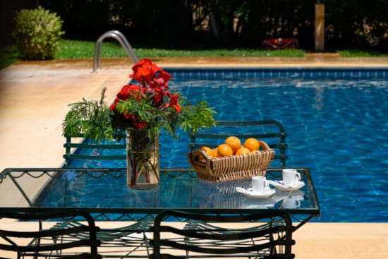 a table with a basket of flowers and a basket of fruit