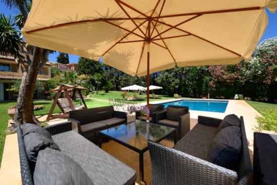 a pool with chairs and umbrella