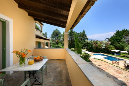 a patio with a table and chairs and a pool