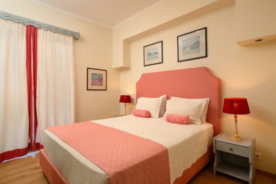 a bed with a red and white comforter