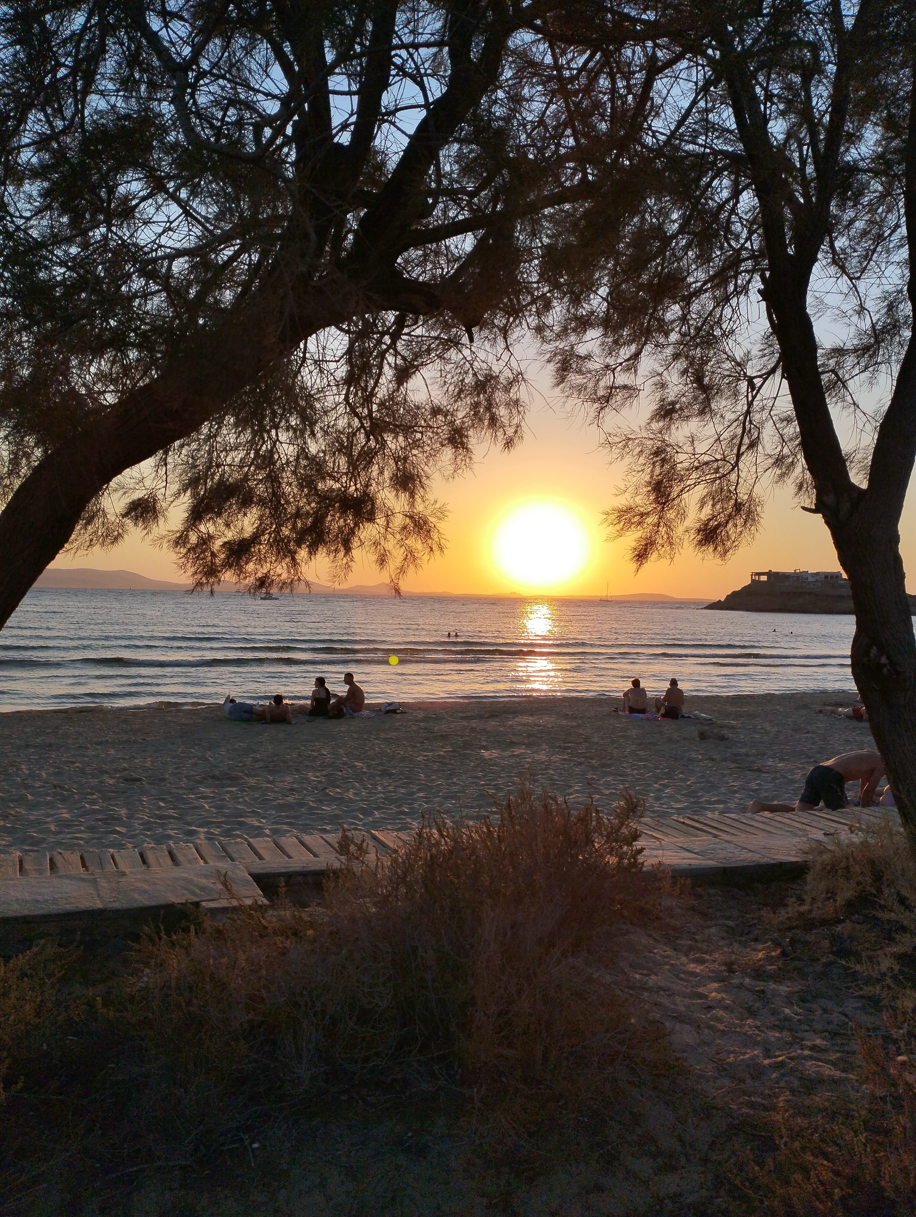 a group of people in a boat on a lake at sunset