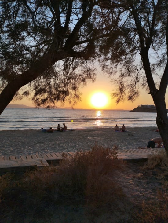 a group of people in a boat on a lake at sunset