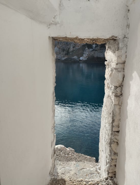 a stone archway with a body of water in the background