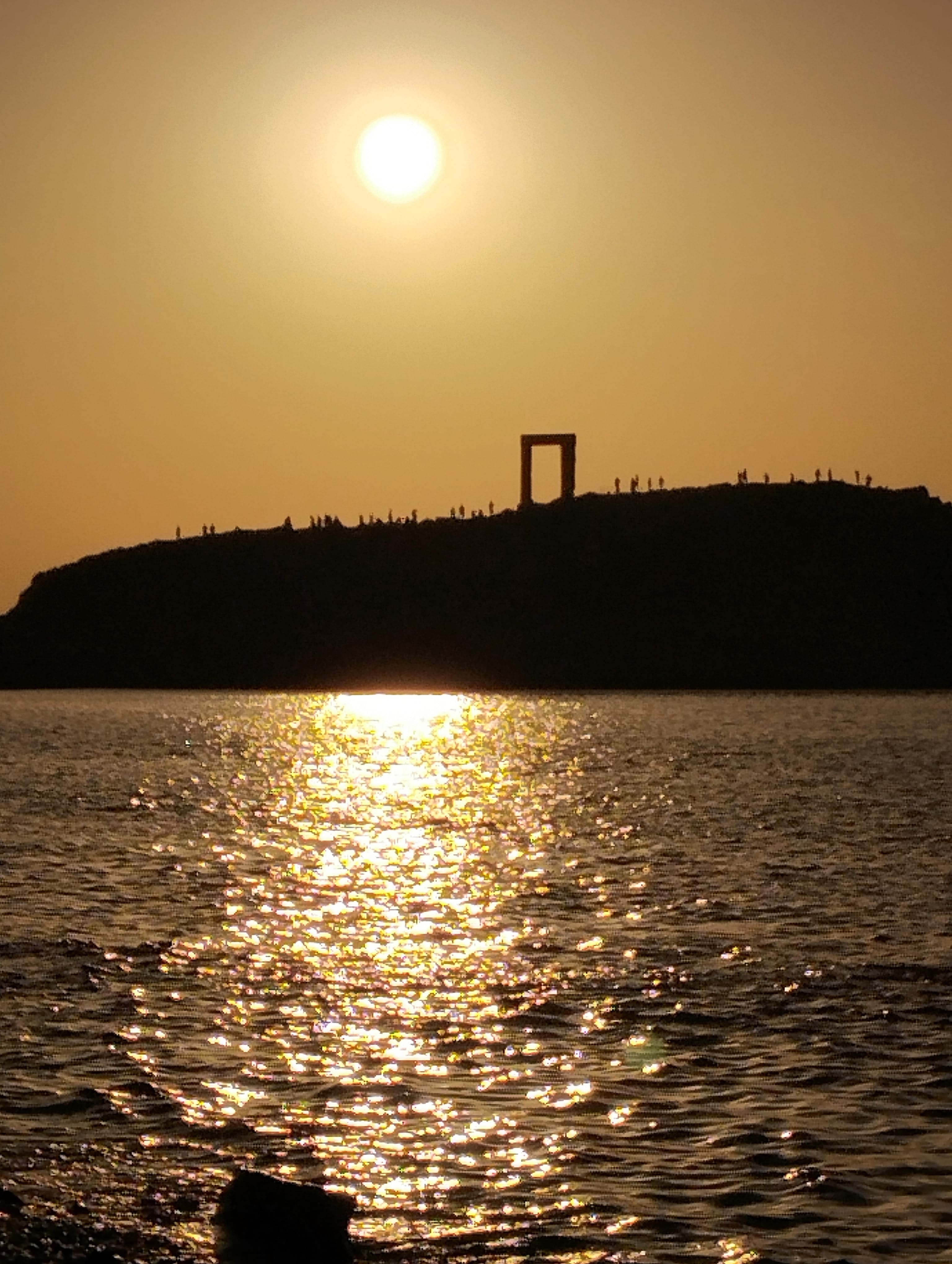 a body of water with a hill in the background