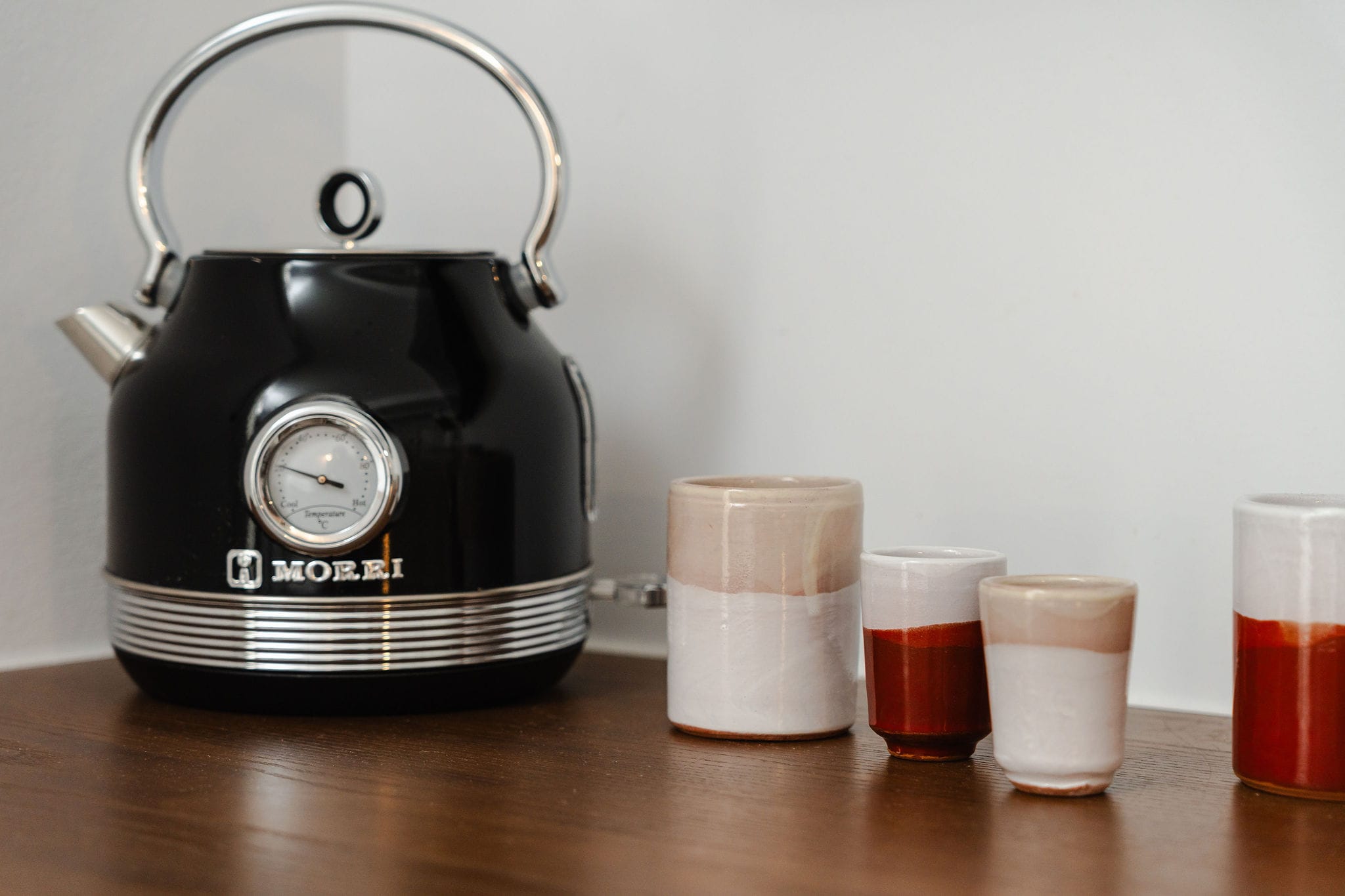 a coffee maker with cups of coffee