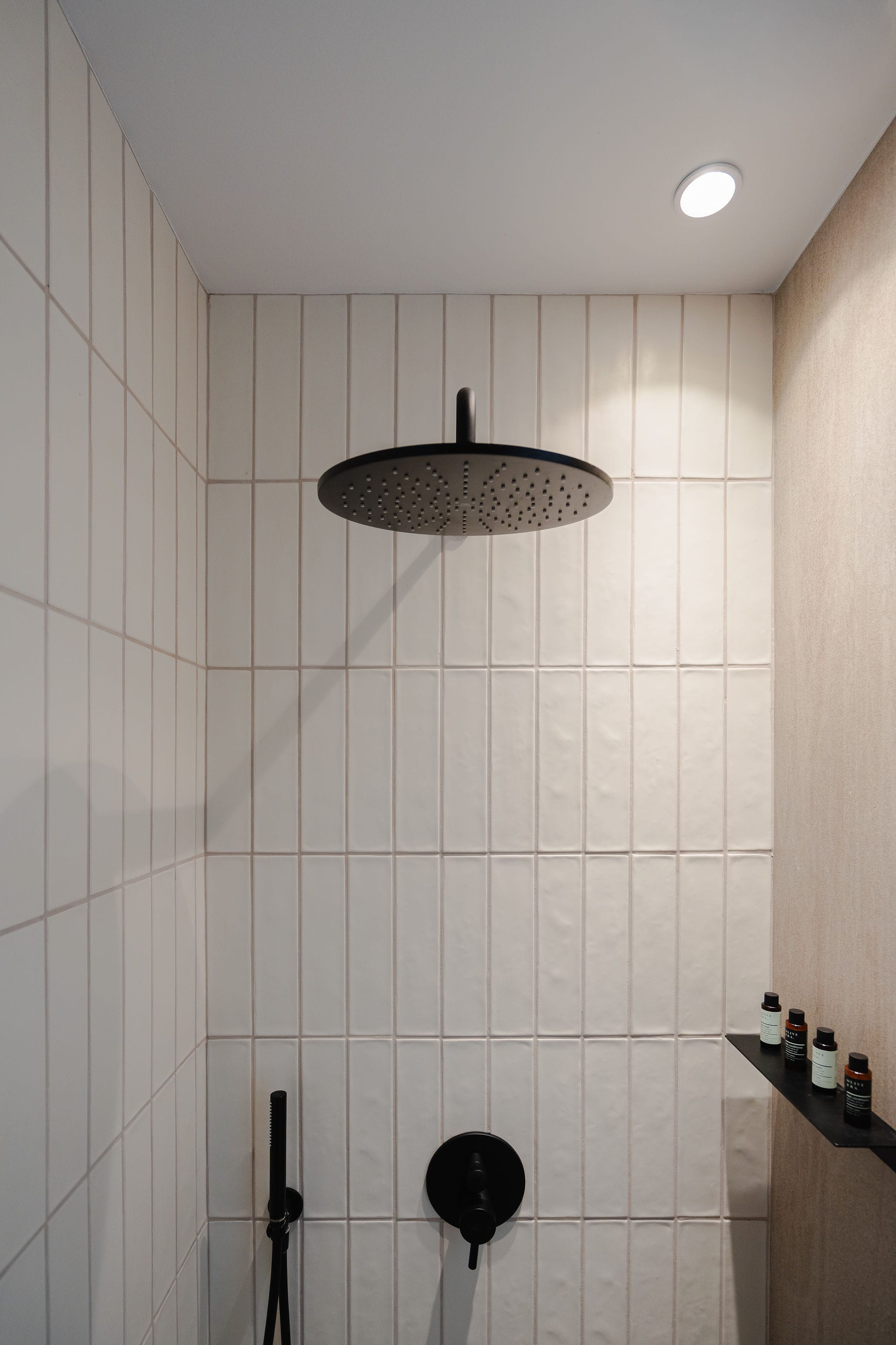 a shower with a tile wall