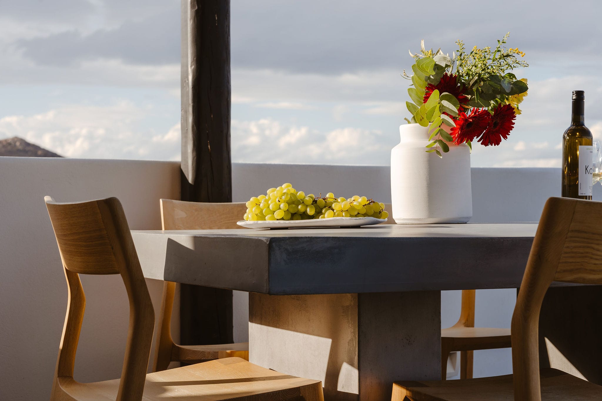 a table with chairs and a vase of flowers on it