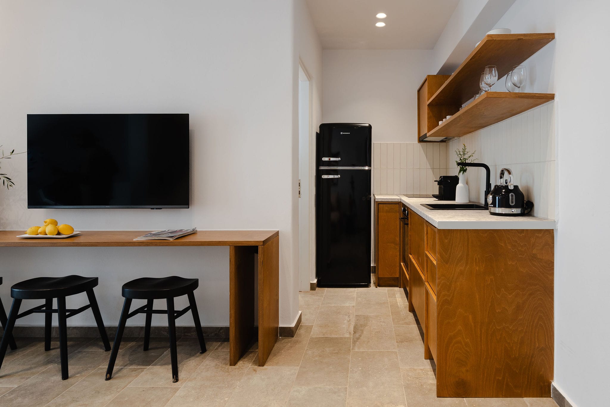 a kitchen with a tv and stools