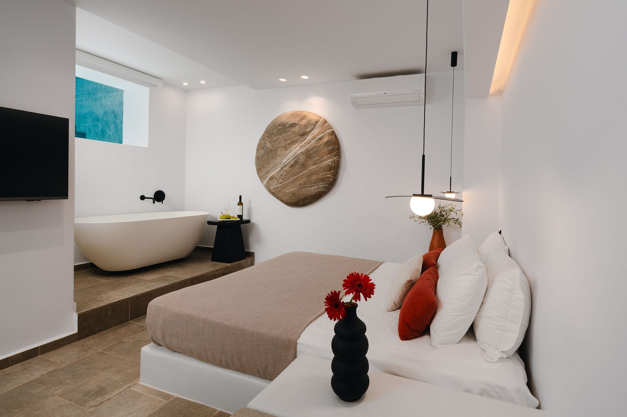 a bathroom with a bathtub and a vase of flowers