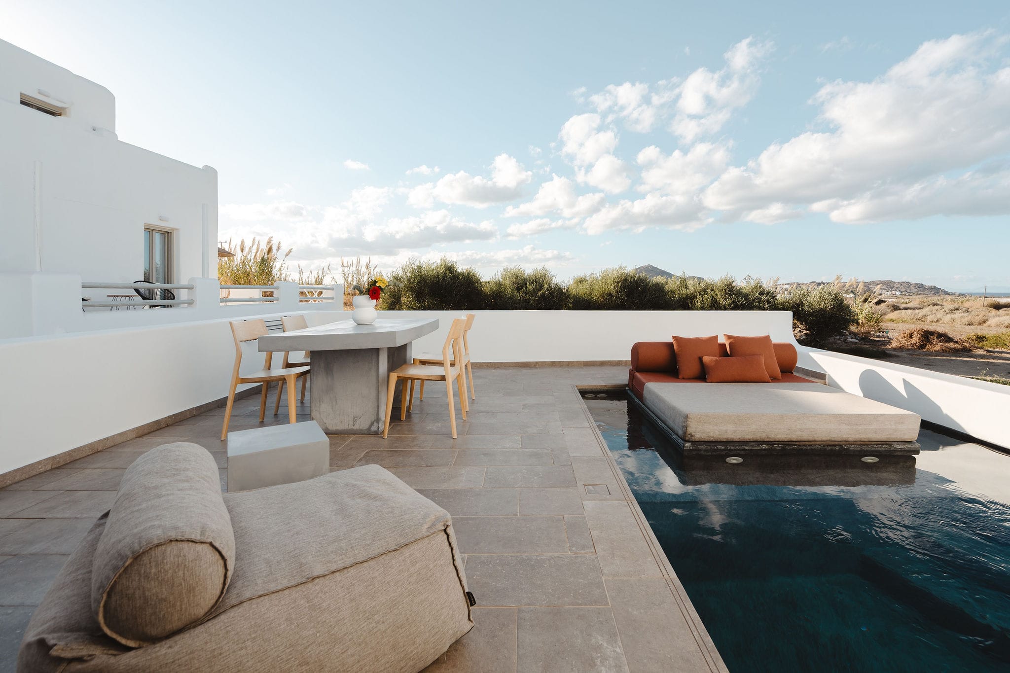 a pool with a lounge chair and a table by it