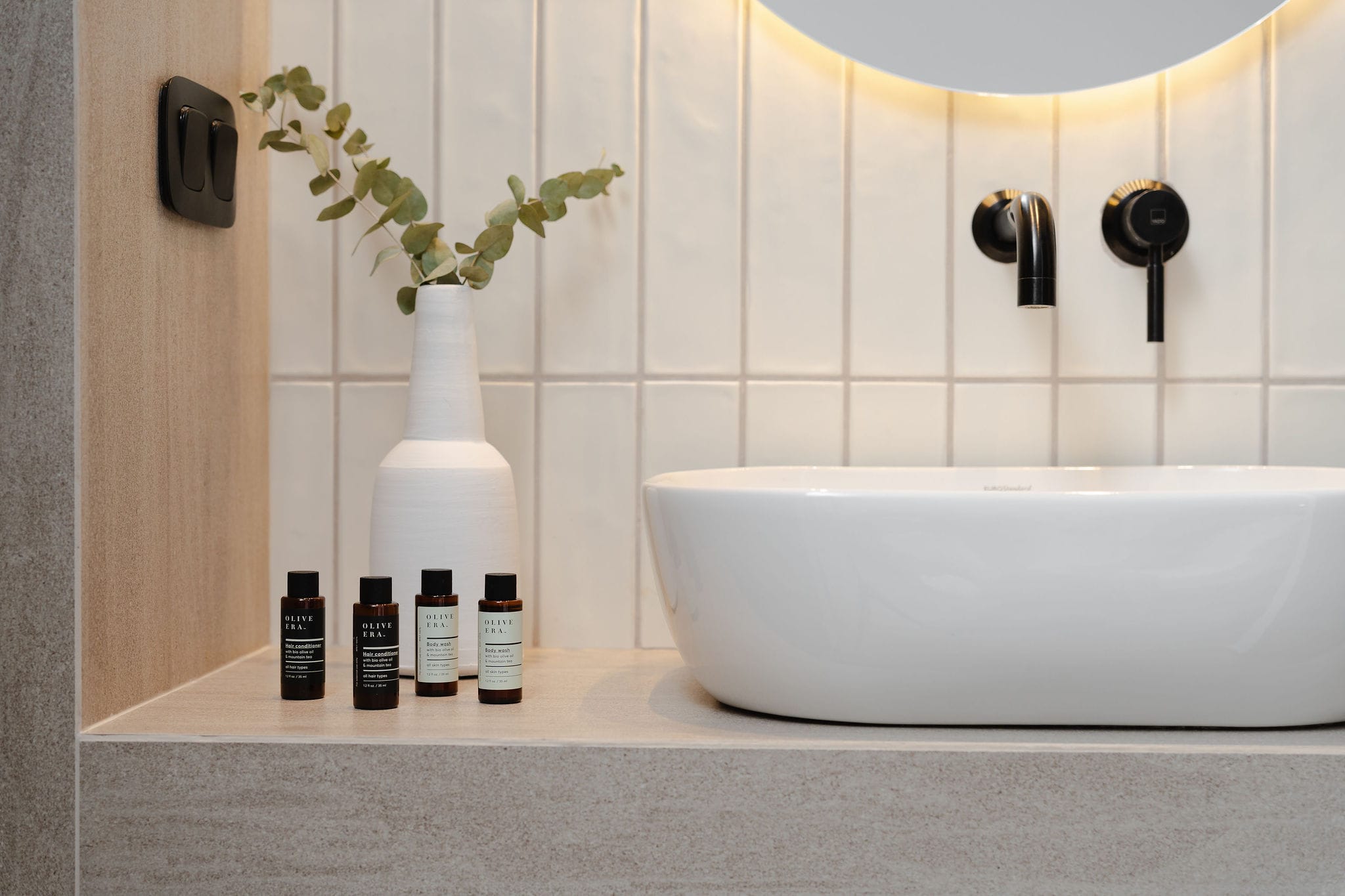 a white bathtub with bottles of perfume on the side