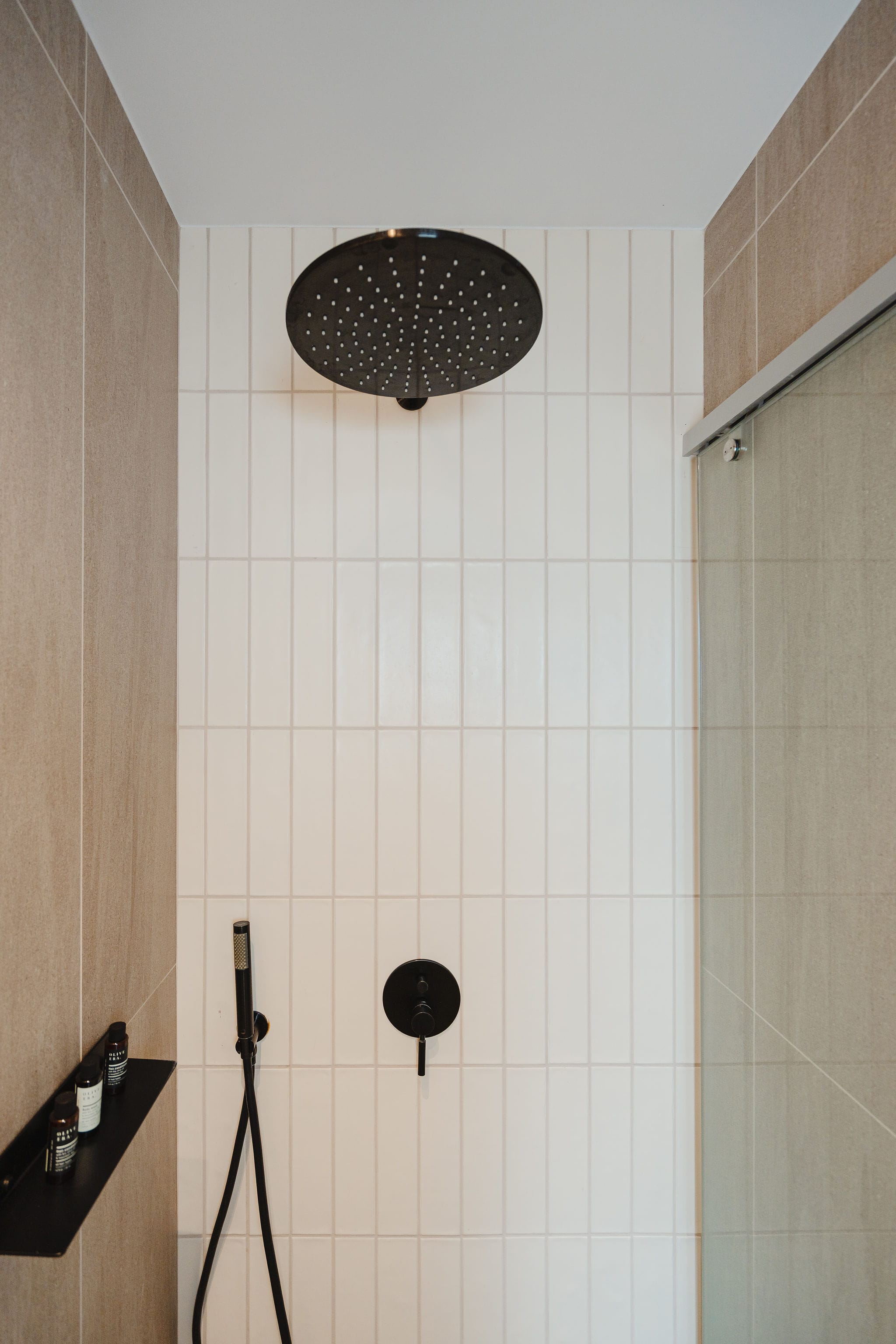 a shower with a tile wall
