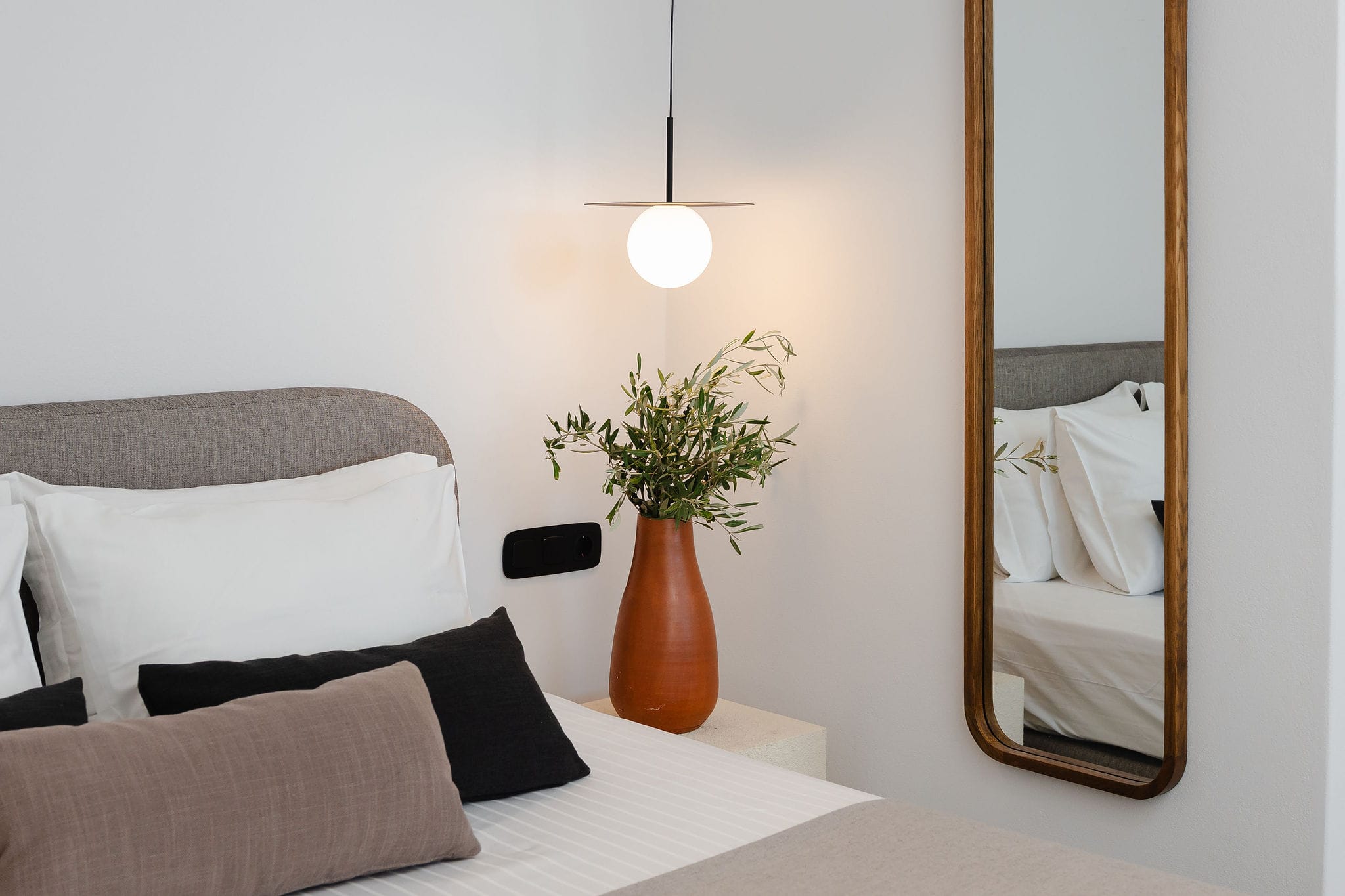 a vase with flowers on a bed