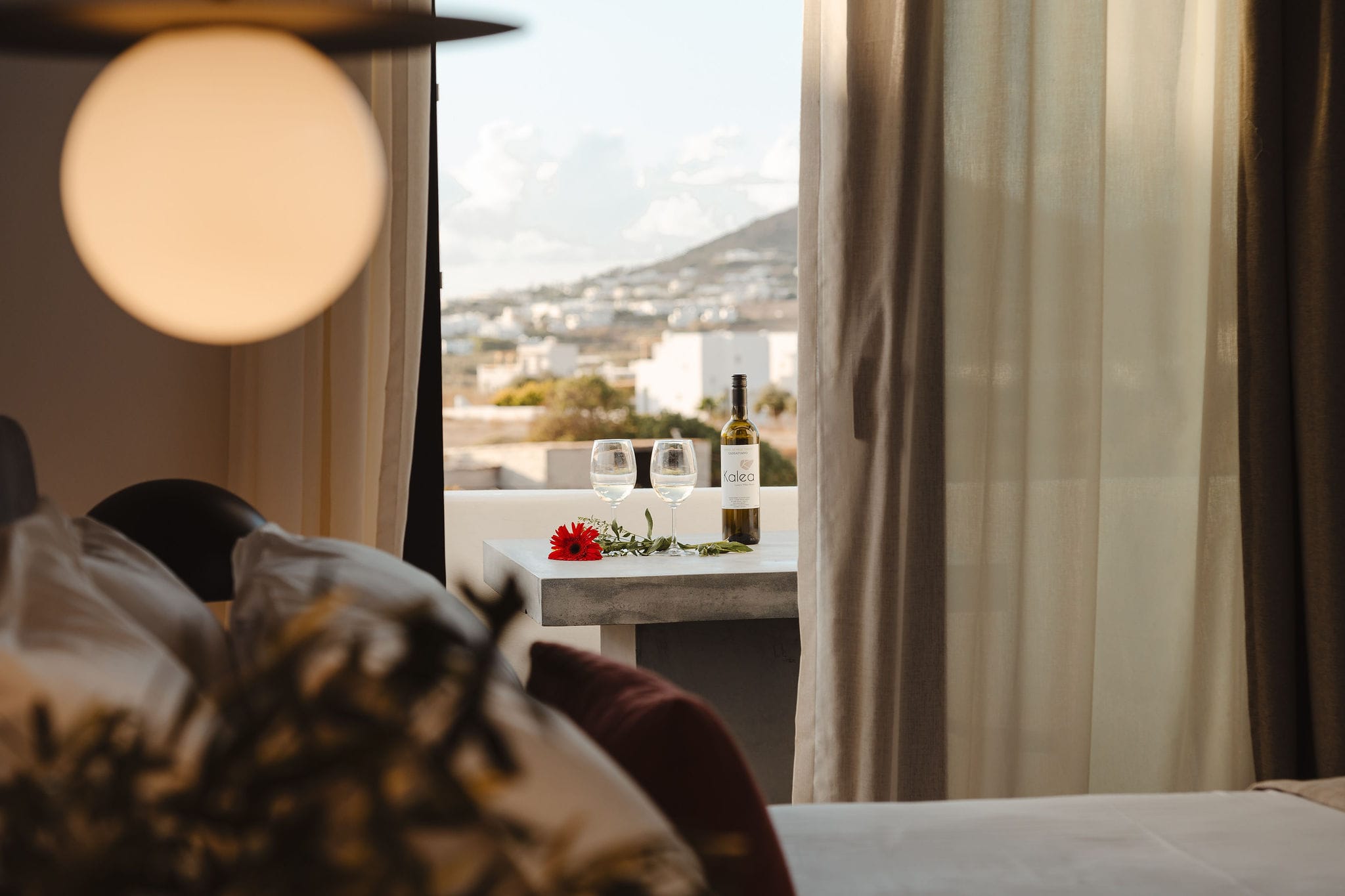 a room with a window and a bed with a lamp on it