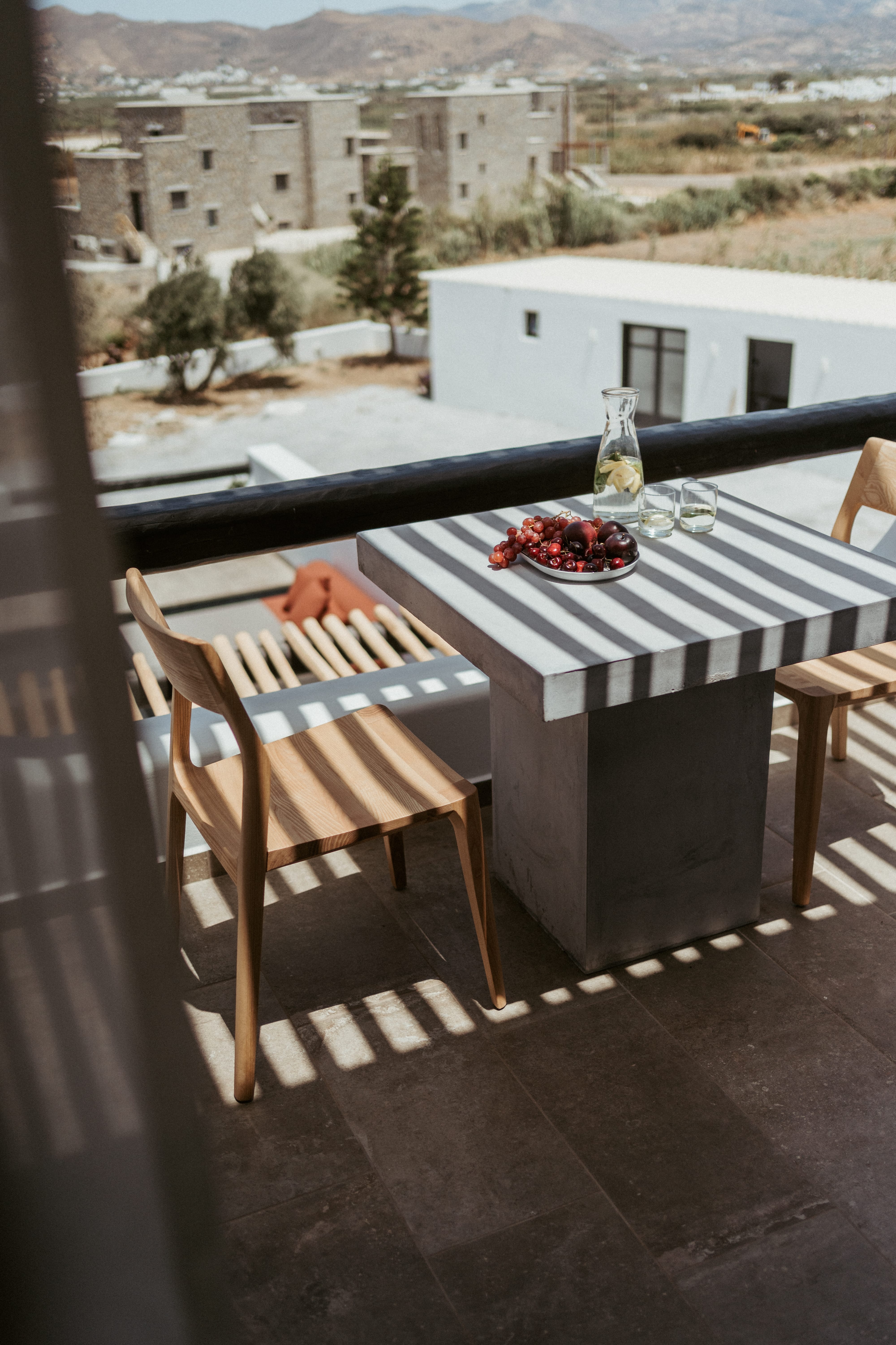 a table with a plate of food on it and a view of a city and a valley