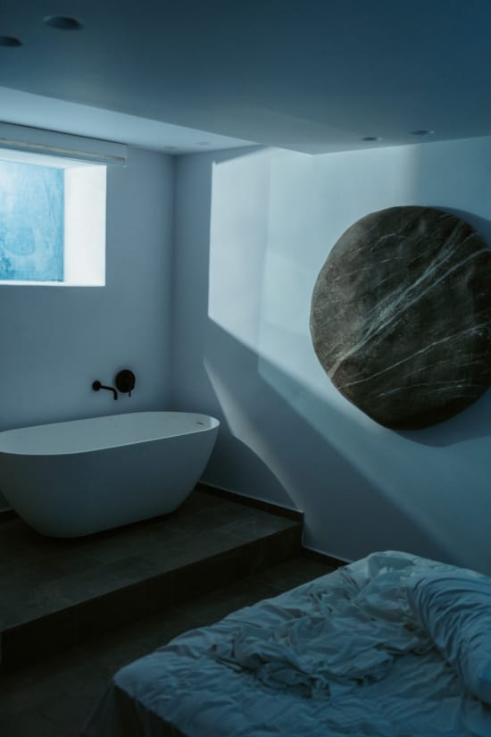 a bathtub and a bed in a bathroom