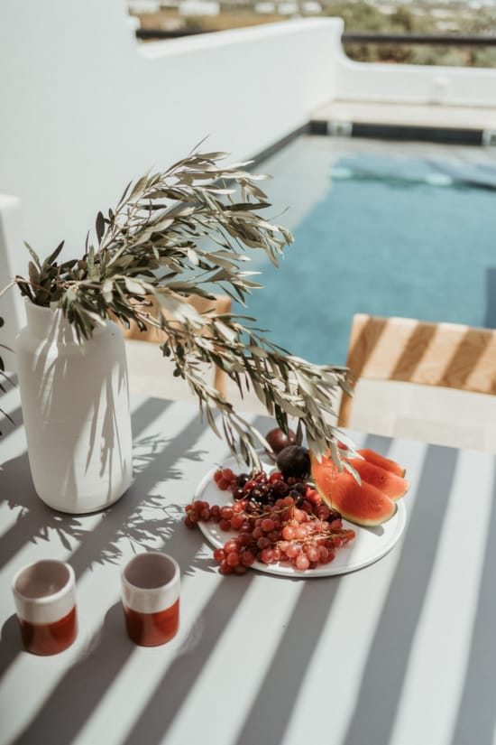 a table with a vase and fruit