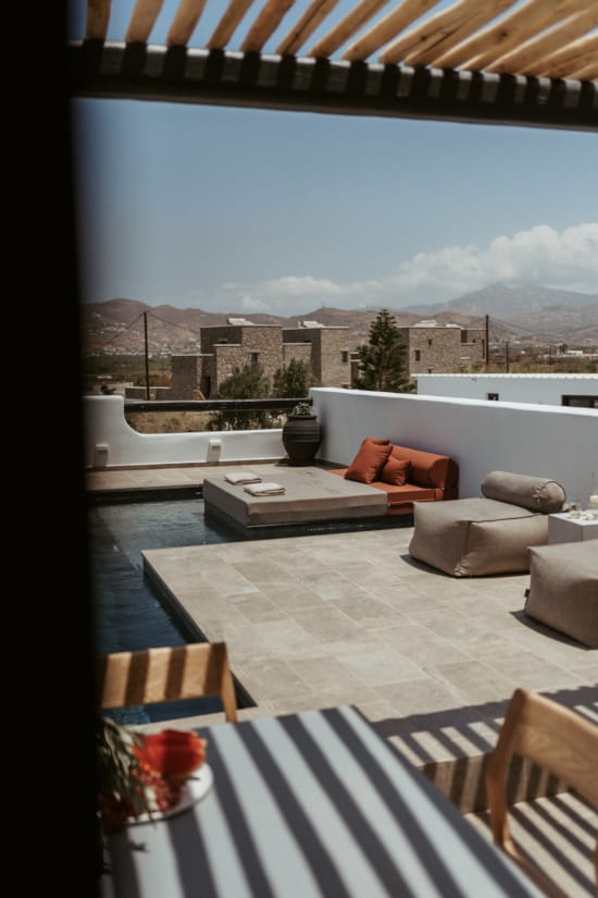 a patio with a table and chairs and a view of a city