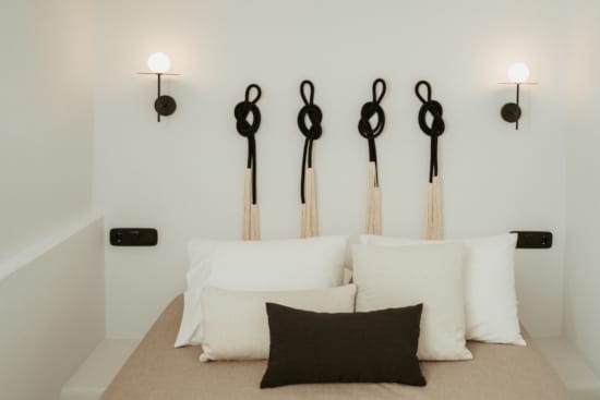 a white bed with black pillows