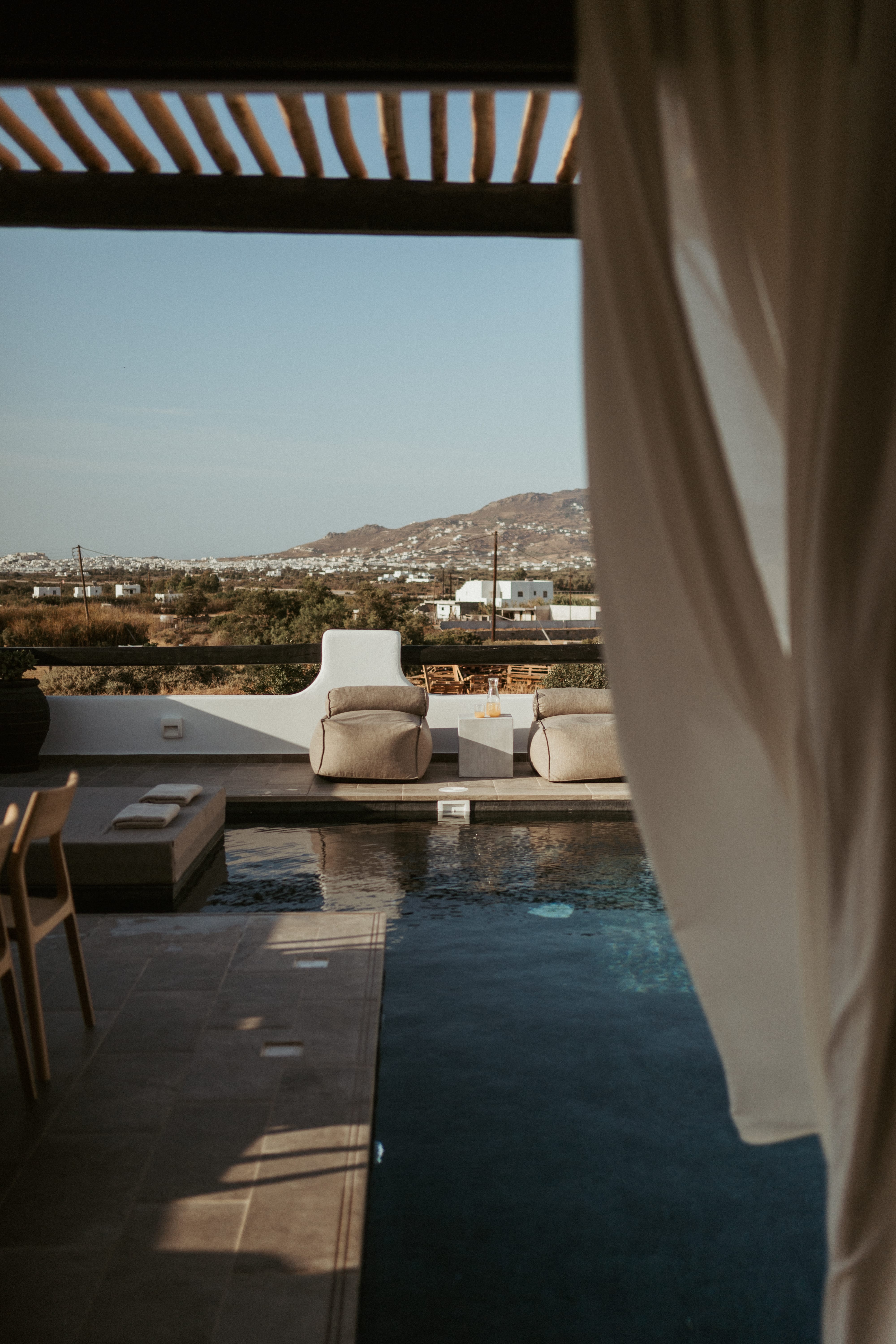 a deck with chairs and a body of water in the background