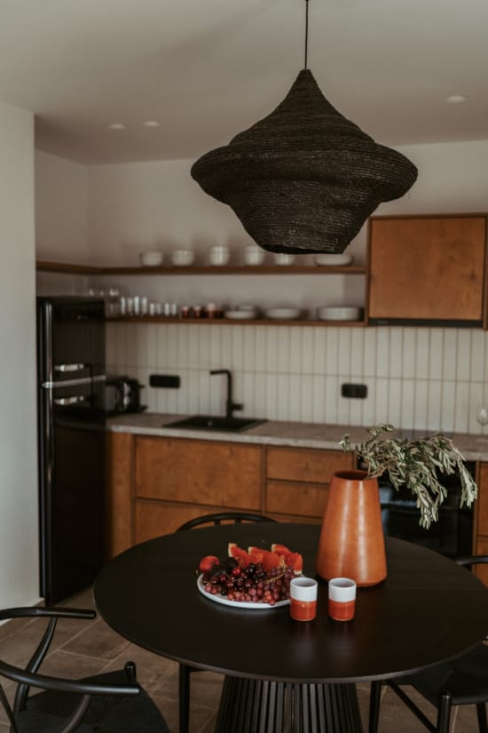 a kitchen with a table and a vase with flowers on it