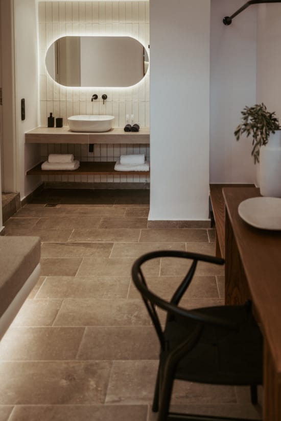 a bathroom with a chair and a mirror