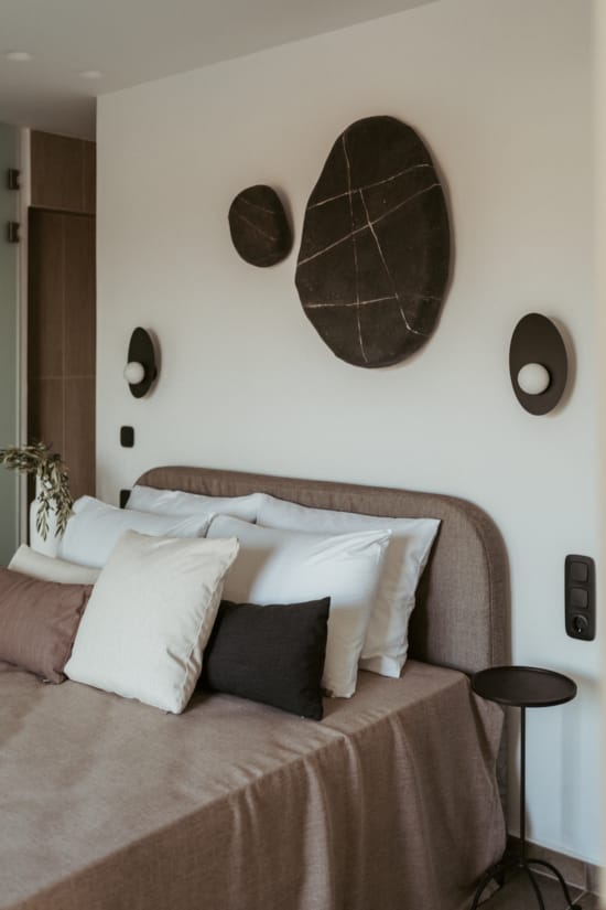 a bed with pillows and a mirror