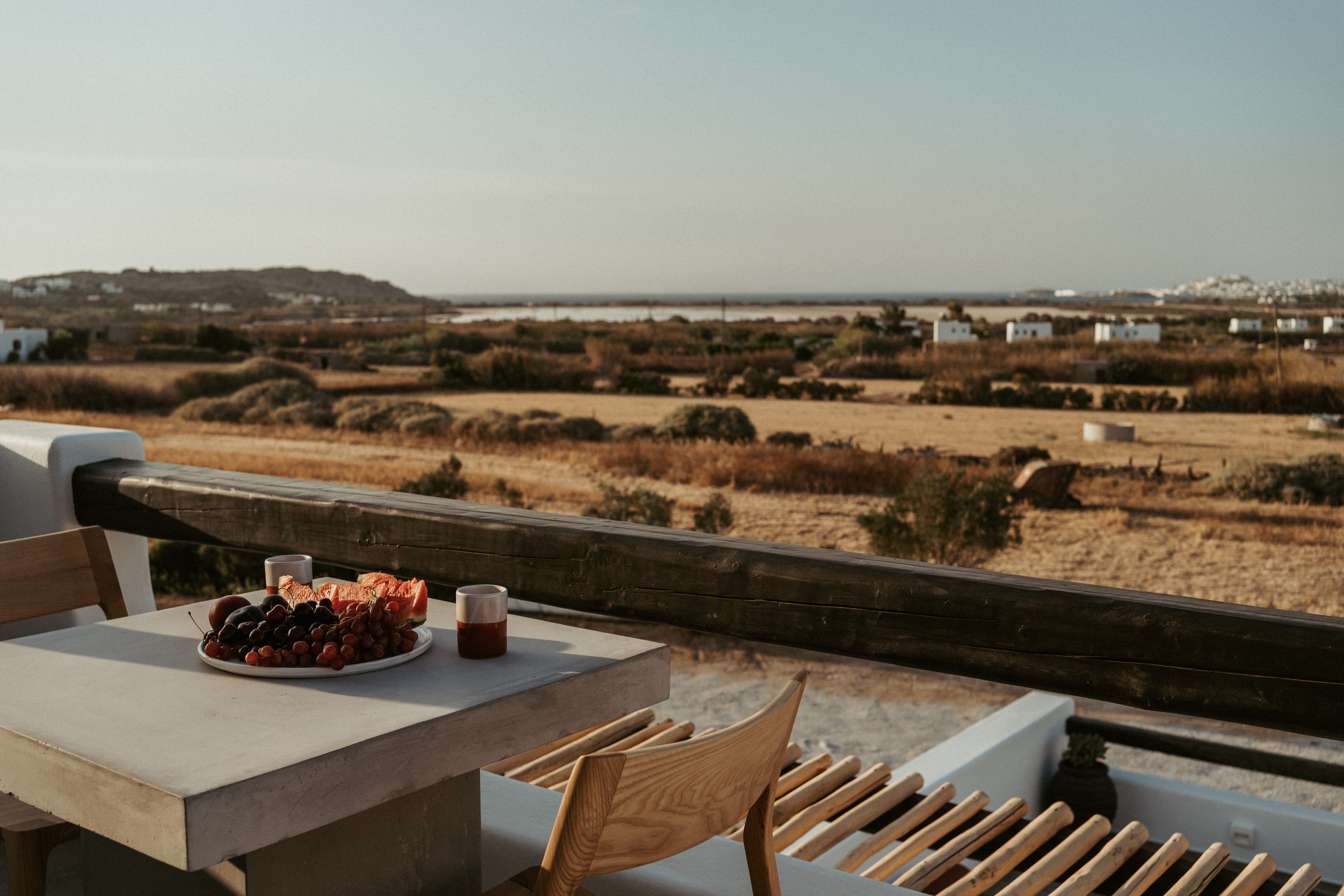 a table with food on it on a balcony overlooking a desert landscape