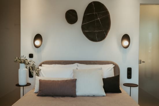 a bed with pillows and a lamp