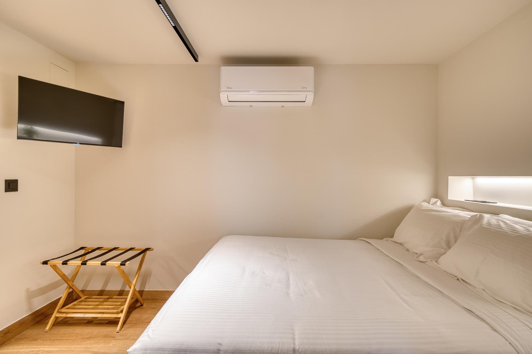 a bed with a tv on the wall