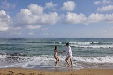 a man and a woman running into the ocean