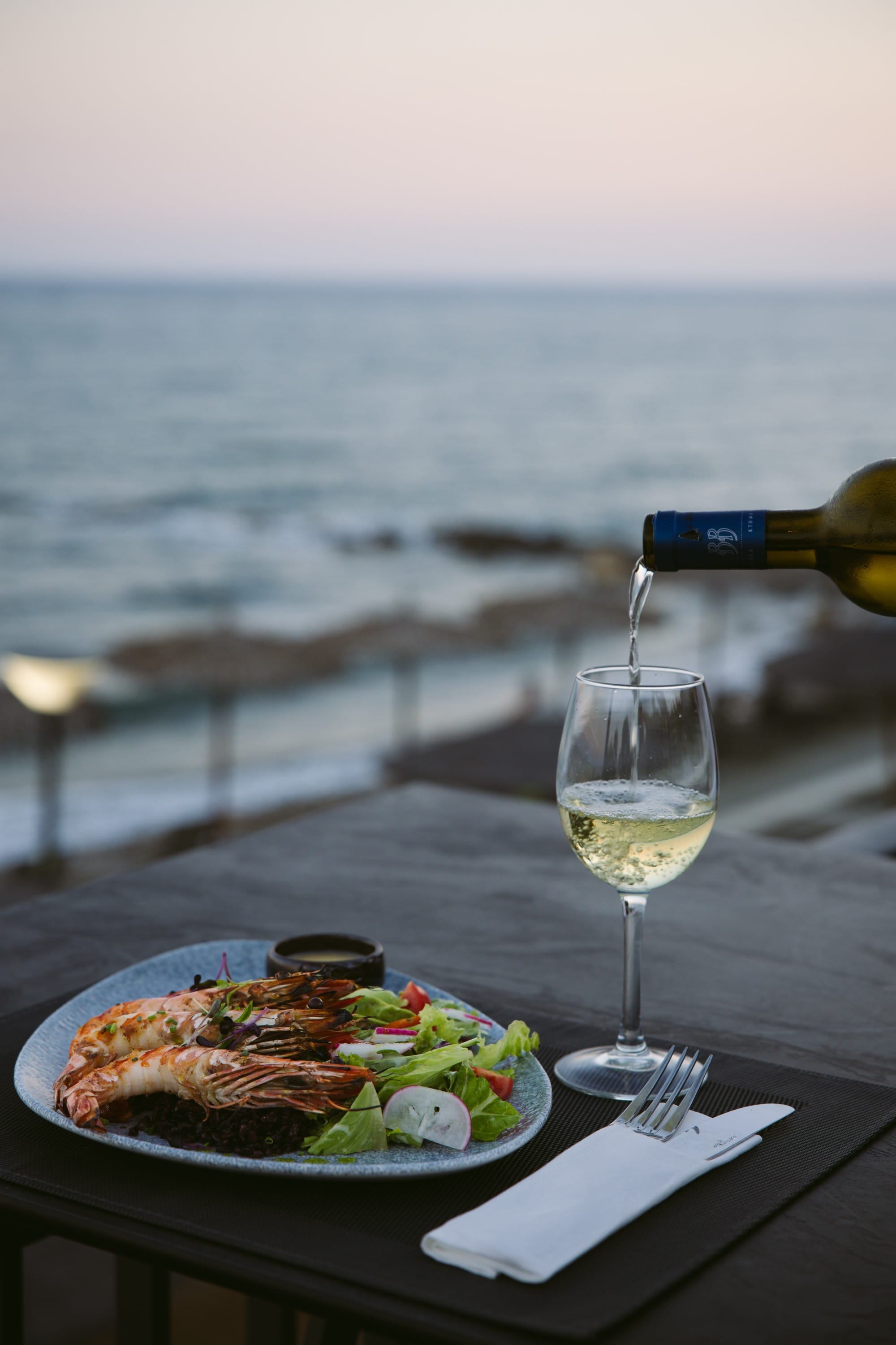 a plate of food and a glass of wine on a table