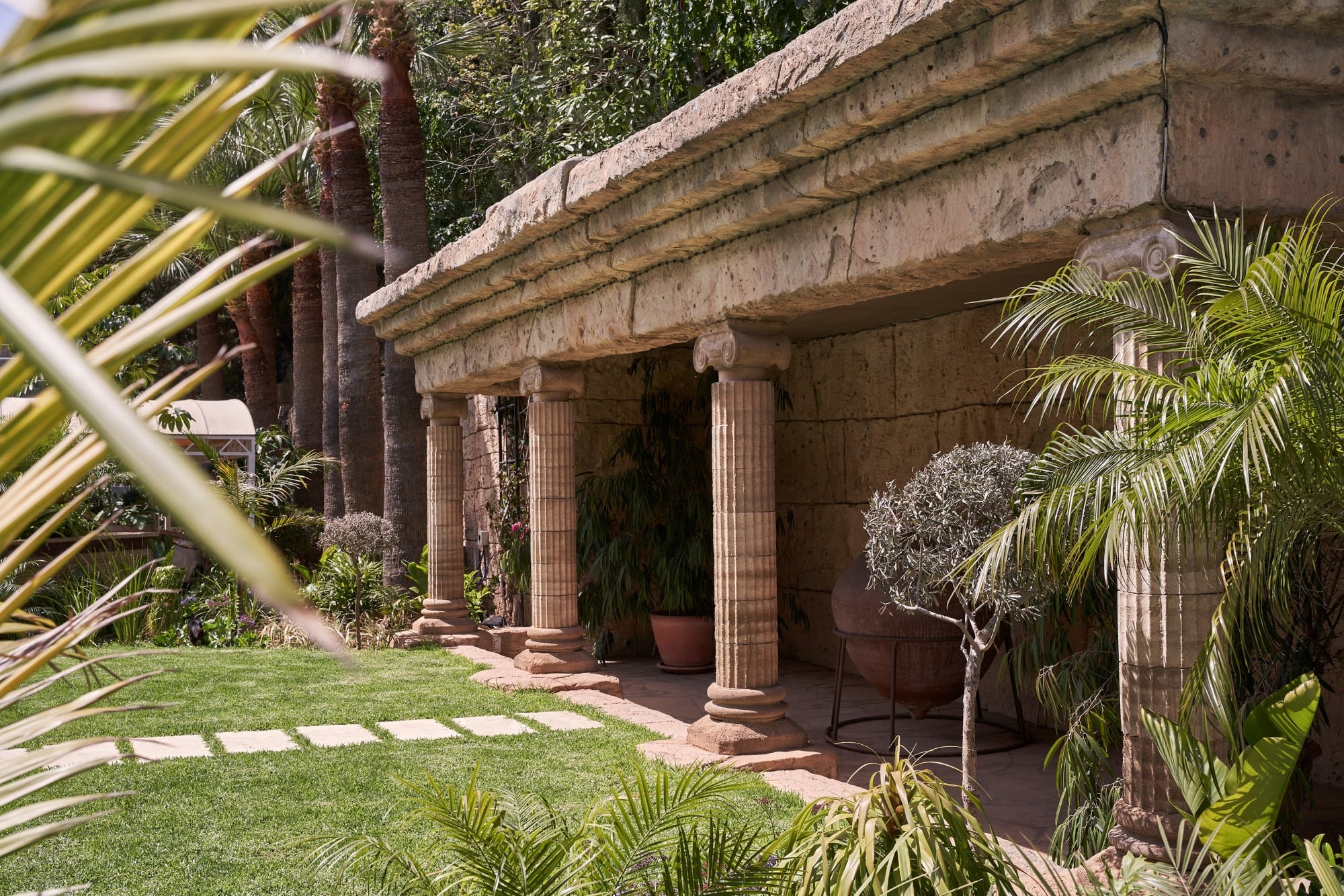 a building with a roof and plants around it