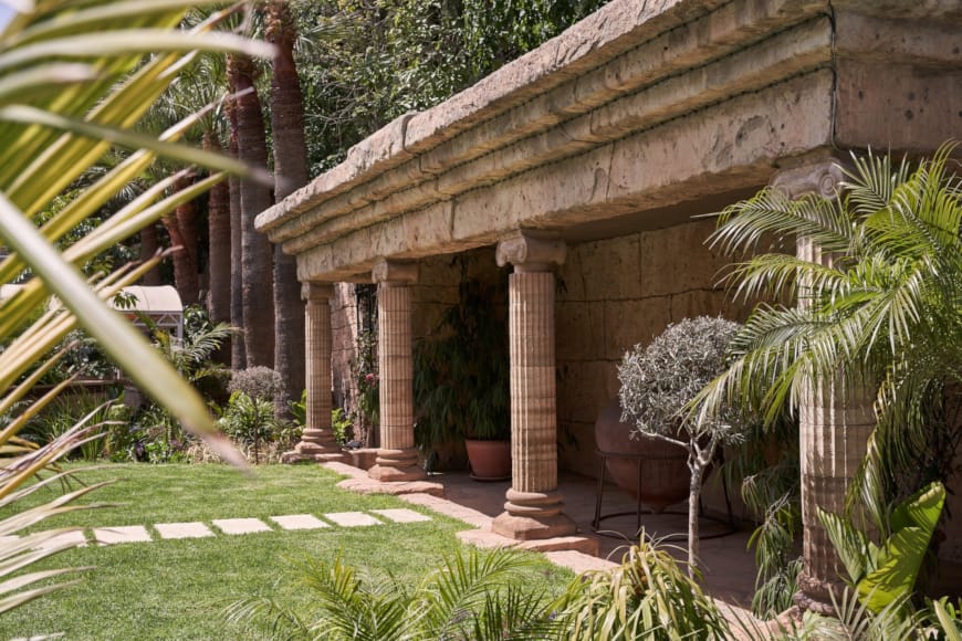 a building with a roof and plants around it